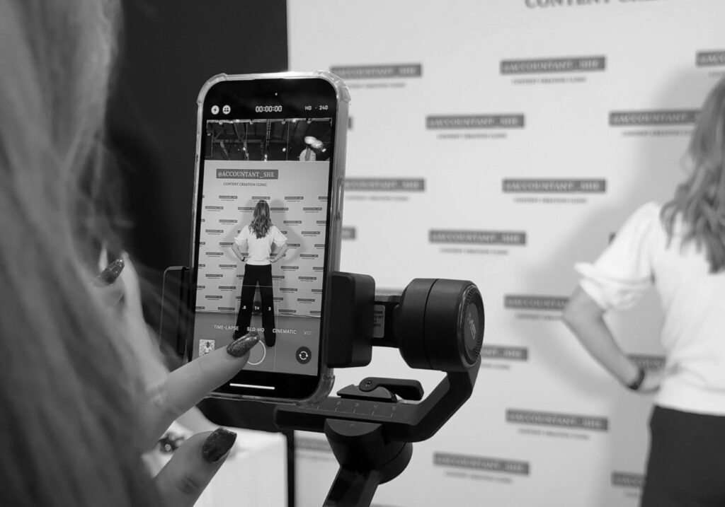 Taz creating content using a phone and gimbal at a conference
