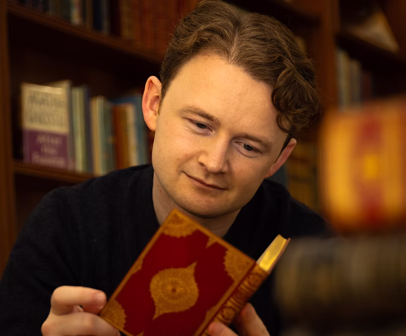 Tom Ayling examining a rare book in his showroom