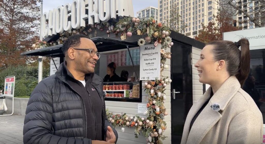 David, founder of Chocofruit, and a member of the striveX team talking outside the Chocofruit kiosk