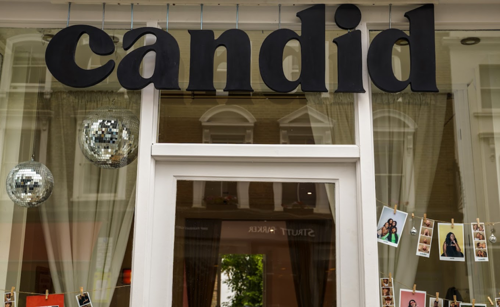 The Candid Studios shopfront sign in Notting Hill, London, decorated with disco balls and printed photo stripsThe Candid Studios shopfront sign on Portobello Road, London, decorated with disco balls and printed photo strips