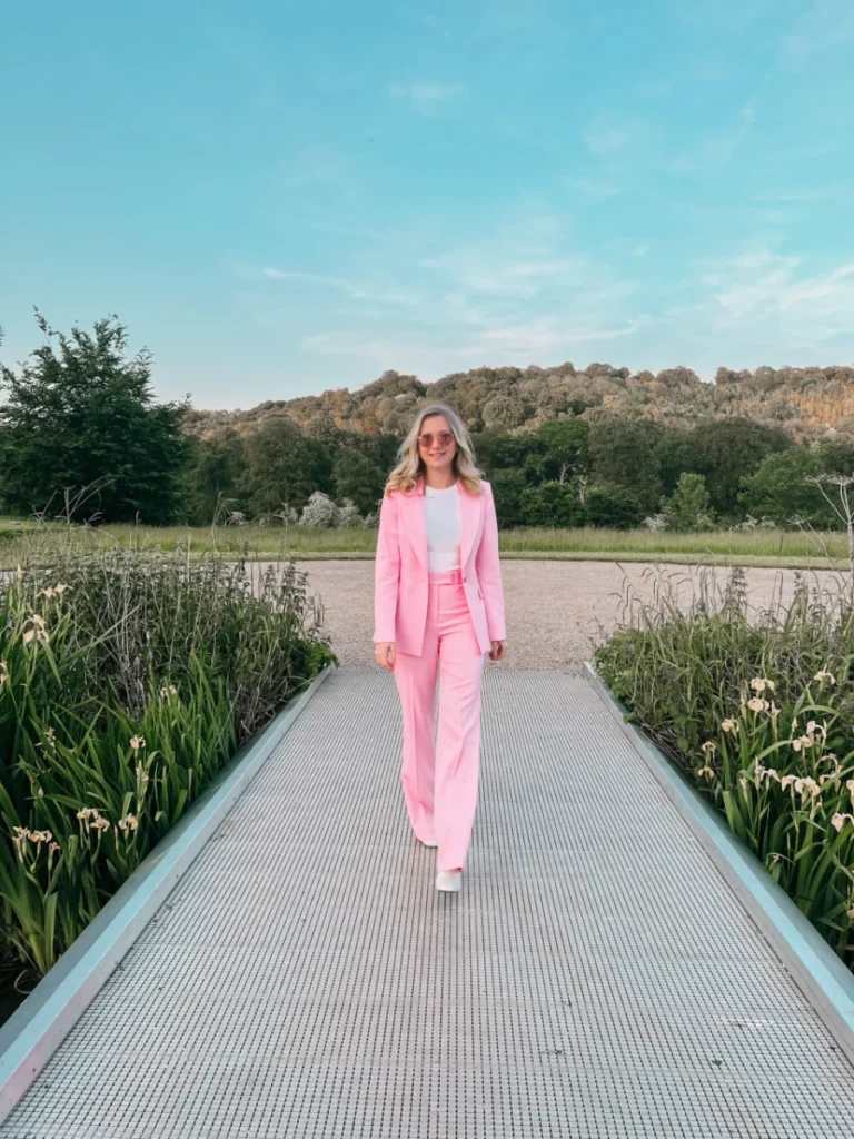 UK subsidiary accountants: woman in a pink suit walking along a waterside path